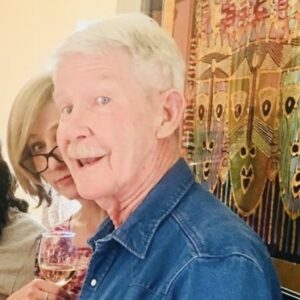 Mike Loughlin smiling while wearing a blue denim shirt, with Lili Francuz standing behind him to his right